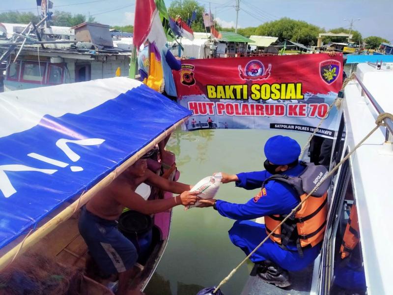 Personel Polair Polres Indramayu membagikan beras kepada nelayan kecil di muara kali Prajagumiwang, Desa Karangsong, Indramayu, Jabar. (Taryani)