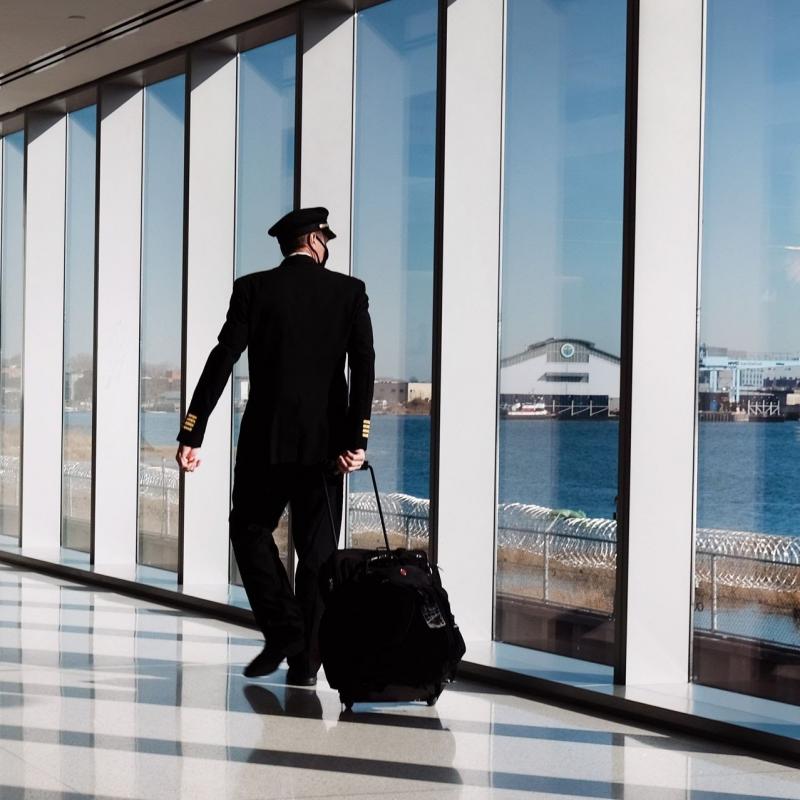 Seorang pilot berjalan di Bandara LaGuardia New York pada 3 Desember 2020 Industri penerbangan mengalami penurunan lalu lintas yang bersejarah karena pandemi. Foto:  PLATT SPENCER / GETTY IMAGES