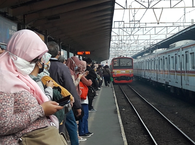 Barisan calon penumpang KRL di peron Stasiun Bekasi.