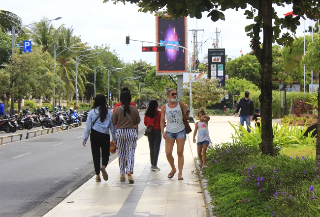 Warga asing dan lokal berjalan di Jalan Kuta, Bali.