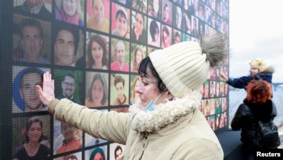 Kerabat korban menghadiri upacara peringatan setahun jatuhnya pesawat milik maskapai Ukraina International Airlines PS752 yang jatuh di wilayah udara Iran, di Kyiv, Ukraina, 8 Januari 2021. (REUTERS / Valentyn Ogirenko)