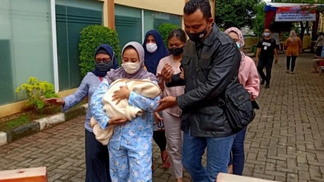 Perempuan yang membawa bayi itu merupakan istri Angga Fernanda Afri. Angga jadi salah satu penumpang yang terdaftar di manifes Sriwijaya Air. (Foto:antara.com)