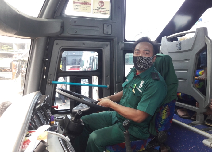 Asep dengan tetap mengikuti protokol kesehatan selama mengendari bus Budiman. 