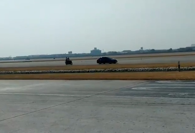 Menggunakan motor, petugas segera mengejar mobil yang memasuki runway