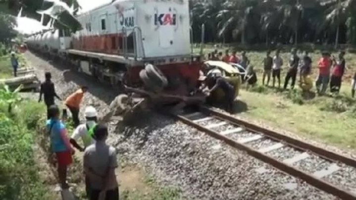 Warga saat akan mengevakuasi badan truk yang ditabrak kereta di Serdangbedagai. (Foto: iNews)
