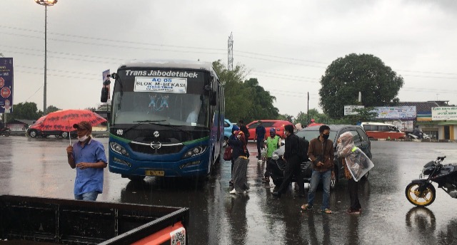 Bus Kota yang tiba langsung diserbu penumpang yang sedari tadi menunggu di tengah hujan deras, Kamis (21/1/2021). Foto: BeritaTrans.com dan Aksi.id.