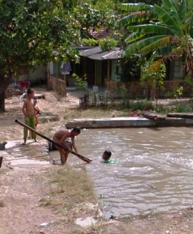 Anak-anak bermain air di saluran irigasi yang airnya penuh karena curah hujan tinggi di Kabupaten Indramayu, Jawa Barat . (Taryani)