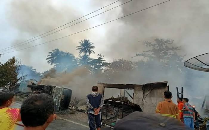 Warga memandangi bangkai mobil dan puing tujuh rumah yang terbakar. Foto: Istimewa