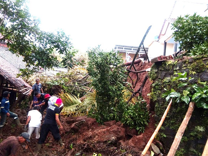 Sejumlah warga bersama Perangkat Desa dan instansi terkait membersihkan material longsor yang  menimbun 3 rumah di Desa Sangkanhurip, Kecamatan Cigandamekar, Kuningan, Jabar. (Ist.)