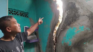 Seorang warga menunjukan retakan rumah akibatnya ledakan pembuatan Tunnel 11 yang kini sudah Ditinggalin pemiliknya. (Foto:Suara.com)