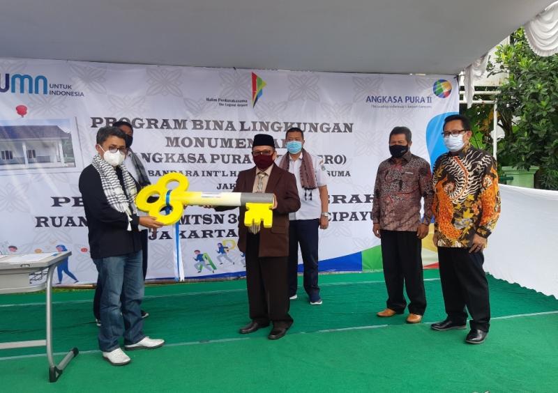 Senior General Manager of Community Development PT Angkasa Pura II, Amirzal memberikan kunci bangunan kelas baru, secara simbolis kepada Kepala MTsN 30 Munjul, H Imam Sayuti, Rabu (10/2/2021)