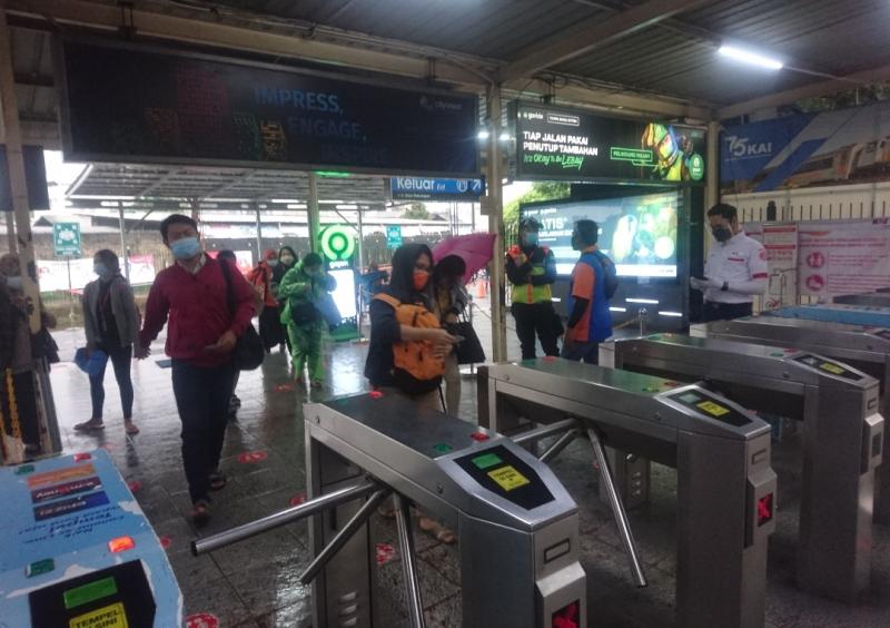 Penumpang KRL di pintu utara Stasiun Bekasi hendak melakukan tap tiket, Selasa (16/2/2021) pagi.