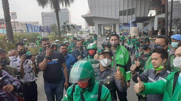 Wali Kota Bekasi Rahmat Effendi duduk di boncengan pengendara ojek online saat melakukan pelepasan ojek online Kota Bekasi kembali mengangkut penumpang di Mega Bekasi Hypermall (MGH), Kamis (9/7/2020). Rencananya, pengendara ojek online akan divaksinasi virus corona pada tahap kedua. Warta Kota/Muhammad Azzam