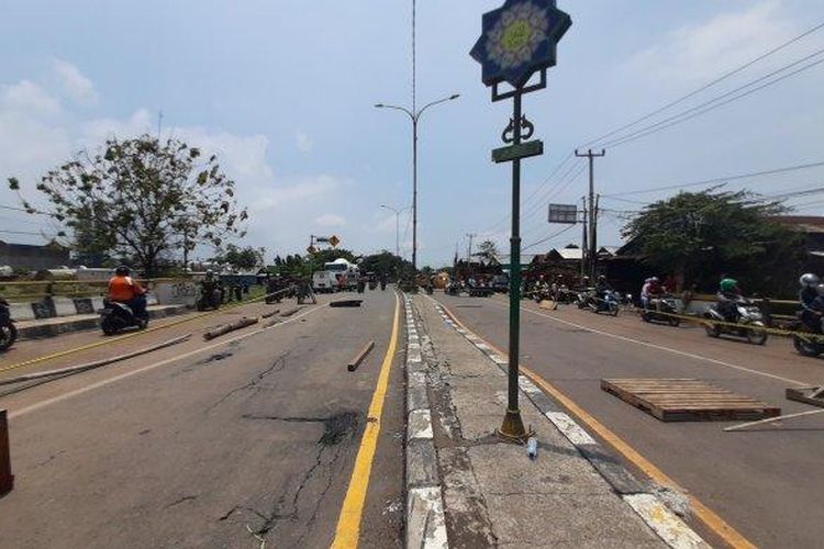 Jembatan Jalan Raya Pacing di Jalur Pantura, Kabupaten Bekasi, yang jadi akses utama ke Kabupaten Karawang, amblas akibat terendam banjir luapan Sungai Citarum. Situasi ini membuat akses lalu lintas terputus untuk dilalui kendaraan besar hingga Senin (22/2/2021). Foto: Kompas.com