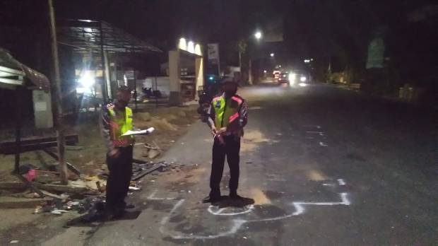 Dua anggota polisi saat melakukan olah TKP di lokasi parkir truk hingga jalan dengan mesin mati dan menabrak sejumlah pengendara lain. Foto: Istimewa