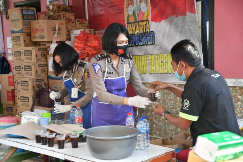 Polwan Korlantas Polri tengah menyerahkan bantuan untuk warga korban banjir di dan dirikan dapur umum di Cipinang Melayu, Jakarta Timur.