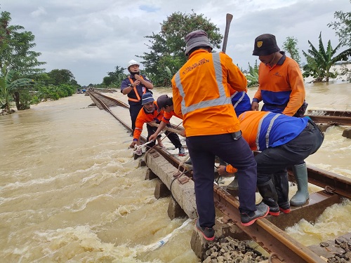 Teknisi  KAI sedang mengatasi rel yang tergenang banjir. (Ist.)