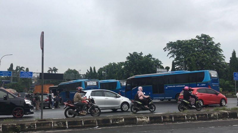 Bus Kota dan Omprengan berbaris panjang menunggu yang tengah menunggu penumpang di depan Gerbang Tol Bekasi Timur, Jumat (26/2/2021). Foto: BeritaTrans.com