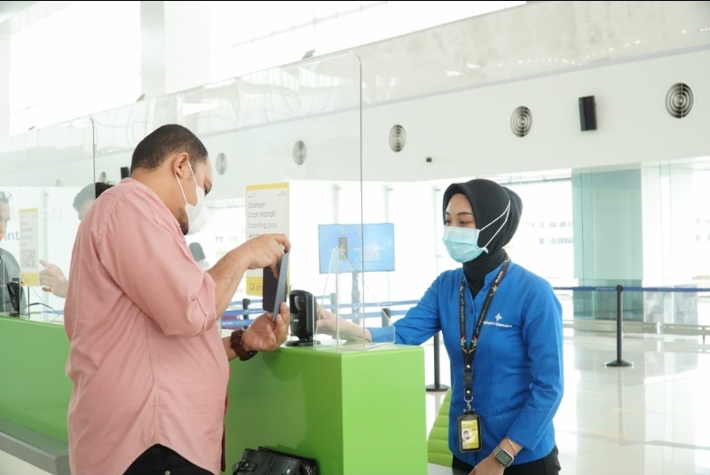 Petugas Bandara Jenderal Ahmad Yani Semarang mengarahkan calon penumpang pesawat udara untuk melakukan pemindaian mandiri _boarding pass_.