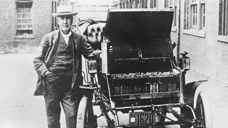 Thomas Edison berpose bersama mobil listrik pertamanya, Edison Baker. Pada foto ini, Edison memegang baterai yang digunakan sebagai sumber tenaga mobil tersebut. Foto: BBCIndonesia.com