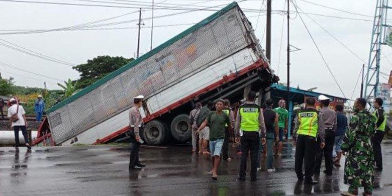 Bangkai truk yang menimpa pengendara motor saat dievakuasi dari dalam kali, Senin (8/2/2021). Foto: Kompas.com