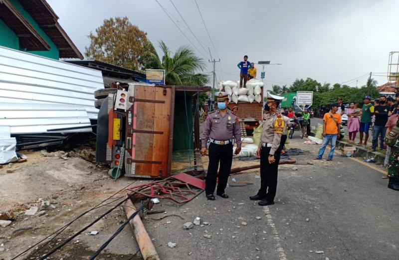 Truk terguling usai menabrak tiga warung dan satu rumah di Kapetakan, Cirebon.
