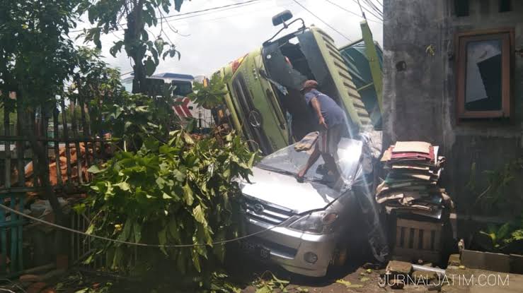Kondisi truk yang terguling menimpa mobil parkir di depan rumah warga, Kamis (11/3/2021). Foto: Jurnaljatim.com