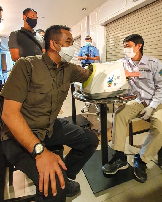 President Director PT Angkasa Pura II Muhammad Awaluddin mencoba alat deteksi tekanan darah di sela  meninjau vaksinasi massal di Bandara Husein, Sabtu (13/3/2021). Foto: Mabruri JW