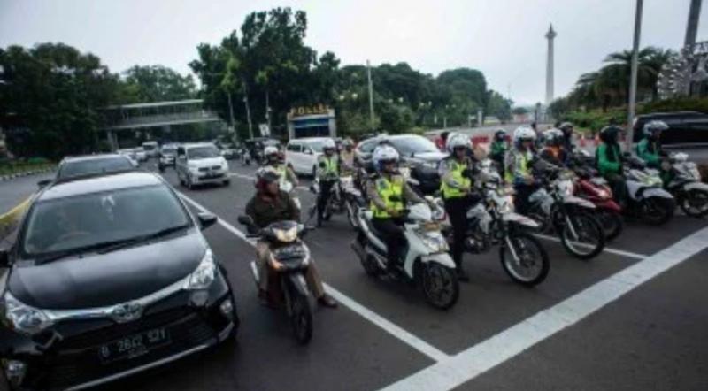 Anggota Satlantas Polres Metro Jakarta Pusat saat melakukan sosialisasi tilang elektronik kepada masyarakat pengguna kendaraan bermotor di jalan Bundaran Patung Kuda, Jakarta.