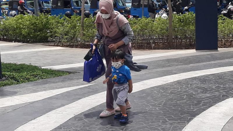 Ibu dan anaknya hendak naik KRL di Stasiun Tanah Abang, Jumat (26/3/2021). Foto: BeritaTrans.com dan Aksi.id.