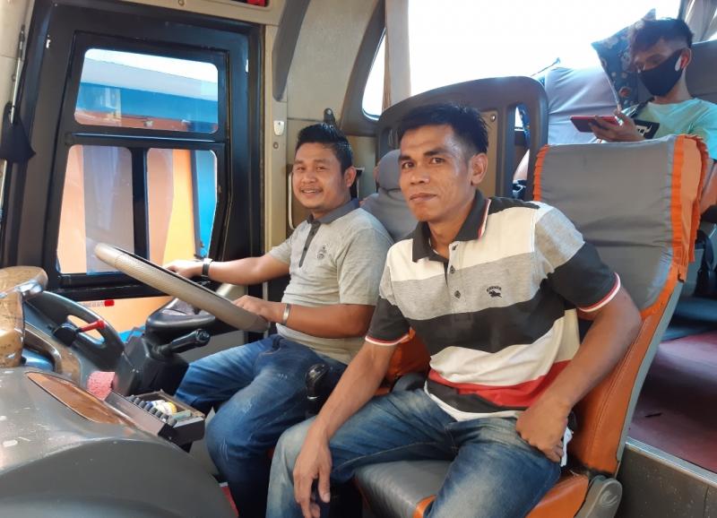 Pengemudi bus ALS jurusan Jakarta-Medan, Riski dan keneknya Nasron sedang menaikkan penumpang di agen ALS Bekasi.  