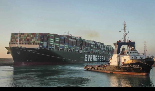 Ever Given, kapal kargo berbendera Panama, ditemani kapal tunda saat melaju di Terusan Suez, Mesir, Senin 29 Maret 2021. (Sumber: Suez Canal Authority via AP)