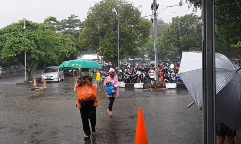 Calon pengguna KRL menuju emplasemen di Stasiun Bekasi saat hujan pada Senin (5/4/2021) pukul 9.00.