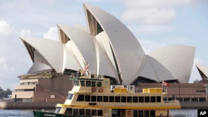 Sebuah kapal feri berlayar melewati Opera House di Sydney, Australia, Selasa, 6 April 2021. (AP Photo/Rick Rycroft)