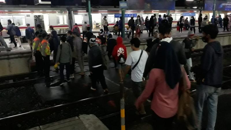 Emak-smak bersama calon penumpang KRL lainnya Seberangi Rel di Stasiun Manggarai, Jumat Malam, 16 April 2021. Foto: BeritaTrans.com dan Aksi.id.