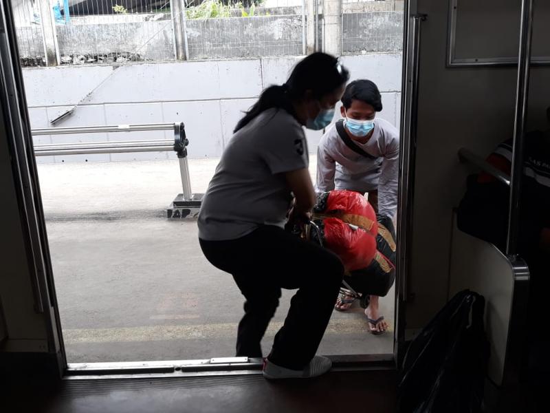 Seorang perempuan tampak susah payah mengangkat barang belanjaan untuk dinaikkan ke KEL di Stasiun Tanah Abang, Sabtu, 17 April 2021. Foto: BeritaTrans.com dan Aksi.id