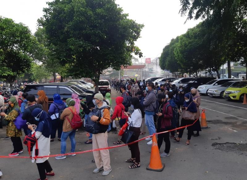 Antrean pengguna KRL mengular di halaman Stasiun Bekasi, Senin (19/4/2021)