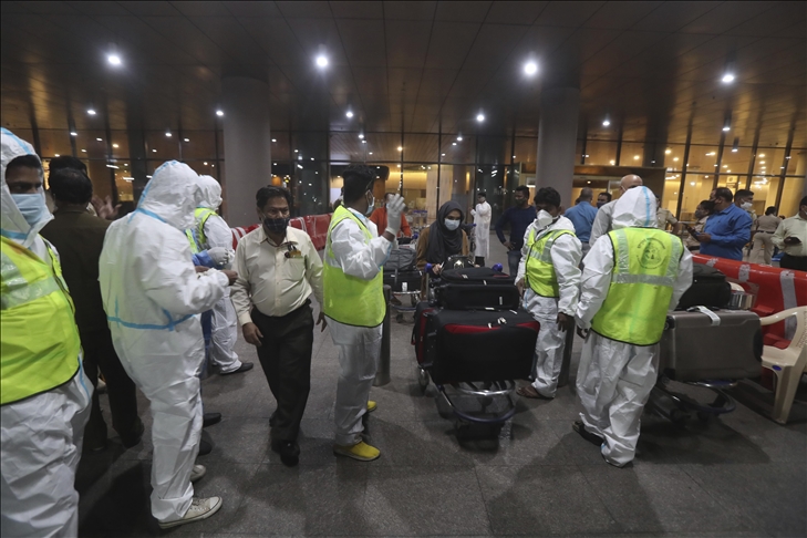 Petugas kesehatan India mengenakan alat pelindung diri memandu penumpang yang tiba dari Inggris, di Bandara Internasional Chhatrapati Shivaji Maharaj di Mumbai, India pada 22 Desember 2020. (Imtiyaz Shaikh - Anadolu Agency) 