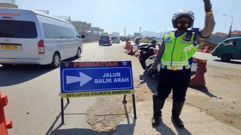 Petugas Satlantas Polresta Bandung memutar balik kendaraan pemudik di GT Cileunyi. (Foto: Istimewa)