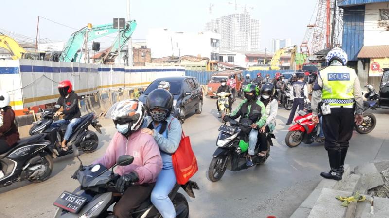 Petugas kepolisian tampak berjuang keras mengatur dan memperlancar arus kendaraan di persimpangan Bulak Kapal, Bekasi, Senin (26/4/3021). Foto: BeritaTrans.com dan Aksi.id.