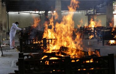 Api membumbung dari tempat kremasi, pihak berwenang mendapatkan permintaan untuk mulai menebang pohon di taman kota, karena New Delhi India telah mengkremasi begitu banyak jenazah. (AP PHOTO/RAJANISH KAKADE)