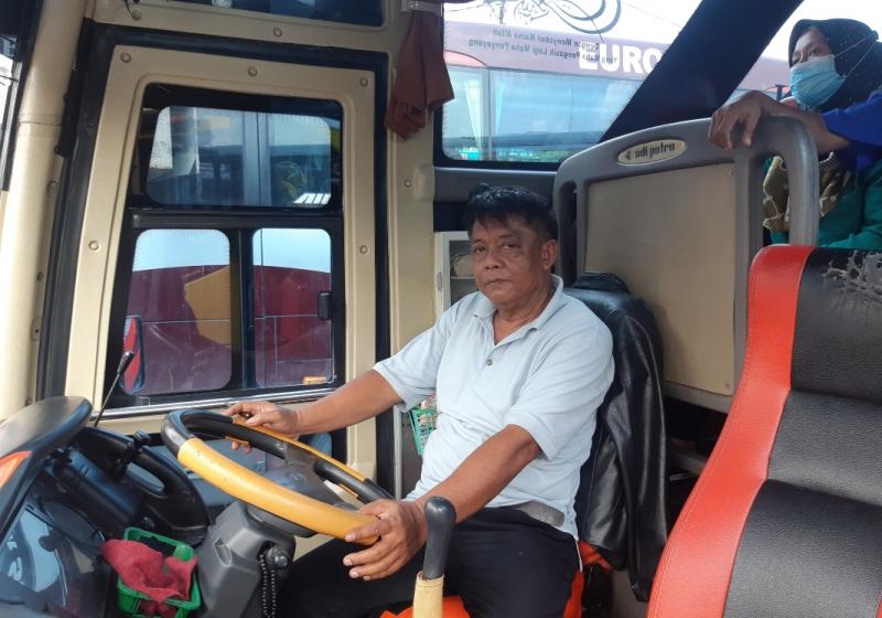 Pengemudi bus PO Dedy Jaya jurusan Bekasi-Slawi, Abdul Warin tengah menunggu busnya terisi lebih banyak penumpang untuk diberangkatkan.