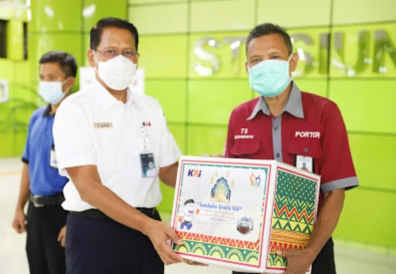 Direktur Utama KAI Didiek Hartantyo (kiri) menyerahkan bantuan secara simbolis kepada seorang porter di Stasiun Gambir. PT Kereta Api Indonesia (Persero) memberikan santunan senilai Rp328.250.000 kepada porter stasiun di berbagai wilayah kerja KAI pada Senin (3/5/2021). 