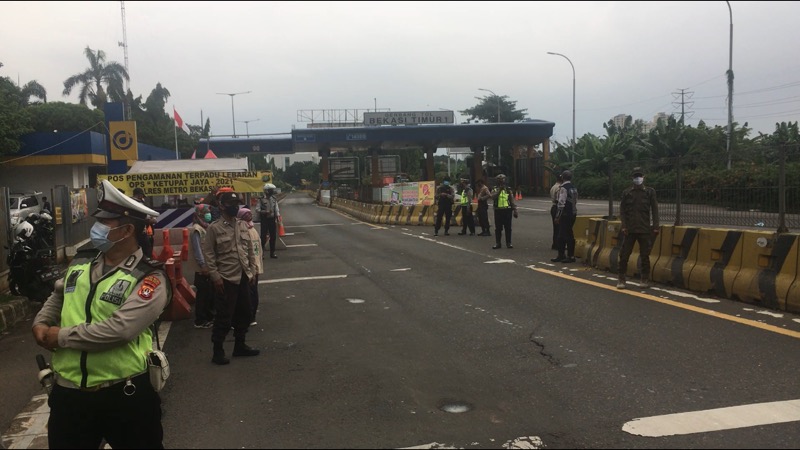 Petugas gabungan berjaga di titik penyekatan depan Gerbang Tol Bekasi Timur, Kamis (6/5/2021). Foto: BeritaTrans.com.