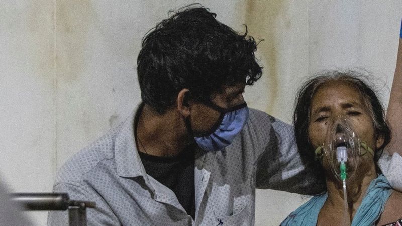 Seorang perempuan menerima bantuan oksigen di tengah pandemi Covid-19 yang melanda India. (REUTERS)