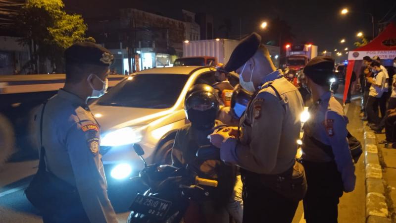 Petugas tengah memeriksa kendaraan roda dua yang melintas. Foto: Polrestro Bekasi.