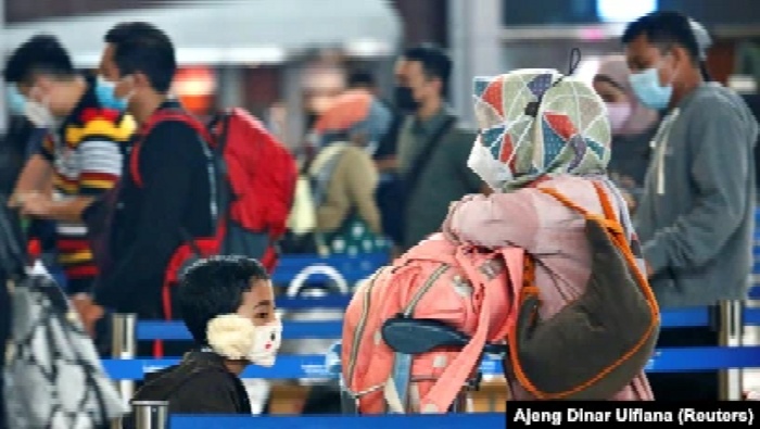 Orang-orang antre untuk check-in tiket dengan barang bawaan mereka di Bandara Soekarno-Hatta, Tangerang untuk mudik lebaran di tengah pandemi COVID-19, 4 Mewi 2021. (REUTERS/Ajeng Dinar Ulfiana)