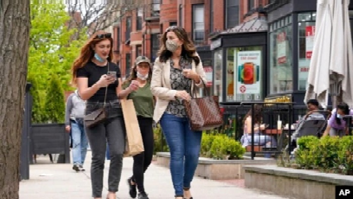 Sejumlah pejalan kaki berjalan di Newsbury Street, Boston, 2 Mei 2021. CDC mengatakan orang yang sudah vaksinasi COVID-19 dosis lengkap tak perlu pakai masker.