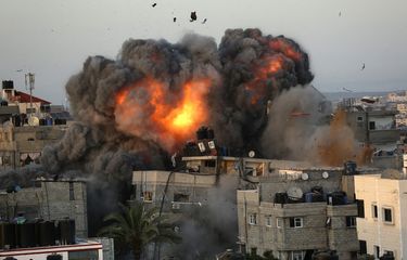 Bola api mengepul dari sebuah gedung di kawsan Rimal, Gaza City, pada 16 Mei, selama bombardir Israel ke area yang dikuasai Hamas tersebut.(AFP PHOTO/BASHAR TALEB)