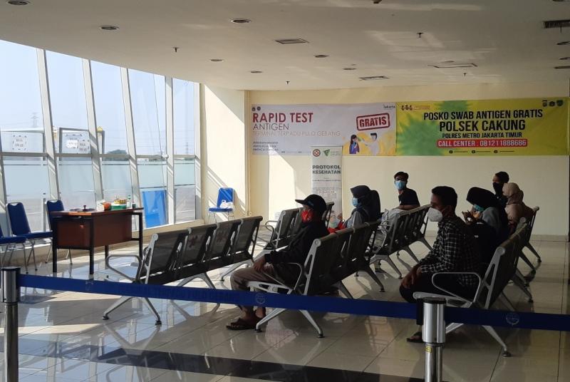 Antrean rapid tes gratis bagi penumpang bus yang baru tiba di Terminal Pulo Gebang, Kamis (20/5/2021).